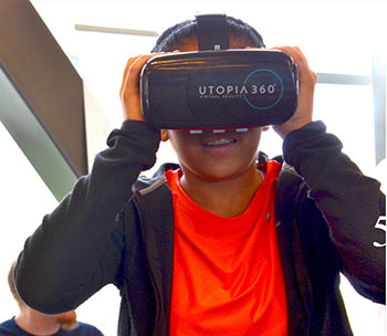 Youth student in the Mason Game and Technology Academy program tries out virtual reality gaming equipment.