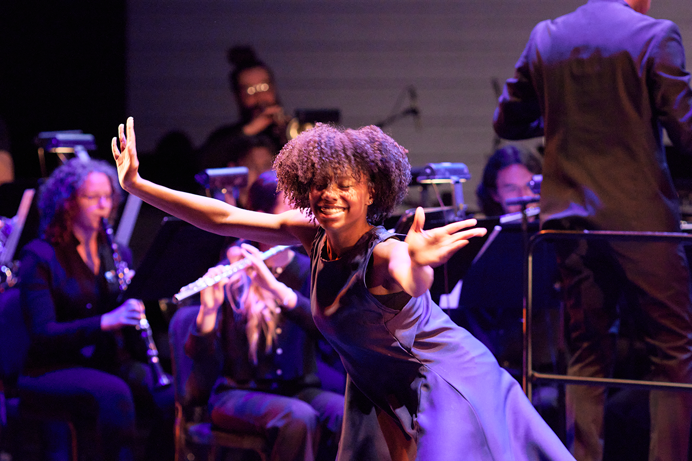 A student from the School of Dance smiles at the audience during the performance of "Come Sunday" by Omar Thomas, performed by the Mason Wind Symphony. Photo by Will Martinez.