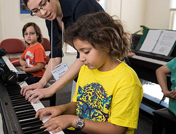 Students learn piano technique in a group setting at the Mason Community Arts Academy